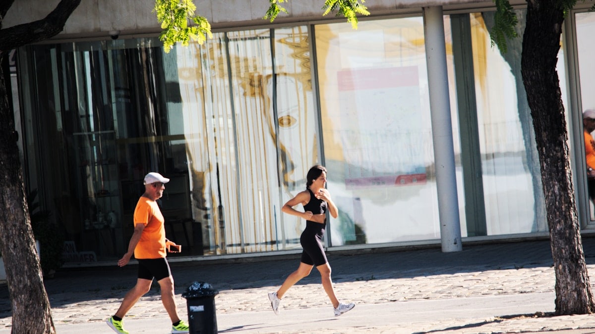 A couple of people that are running down a street